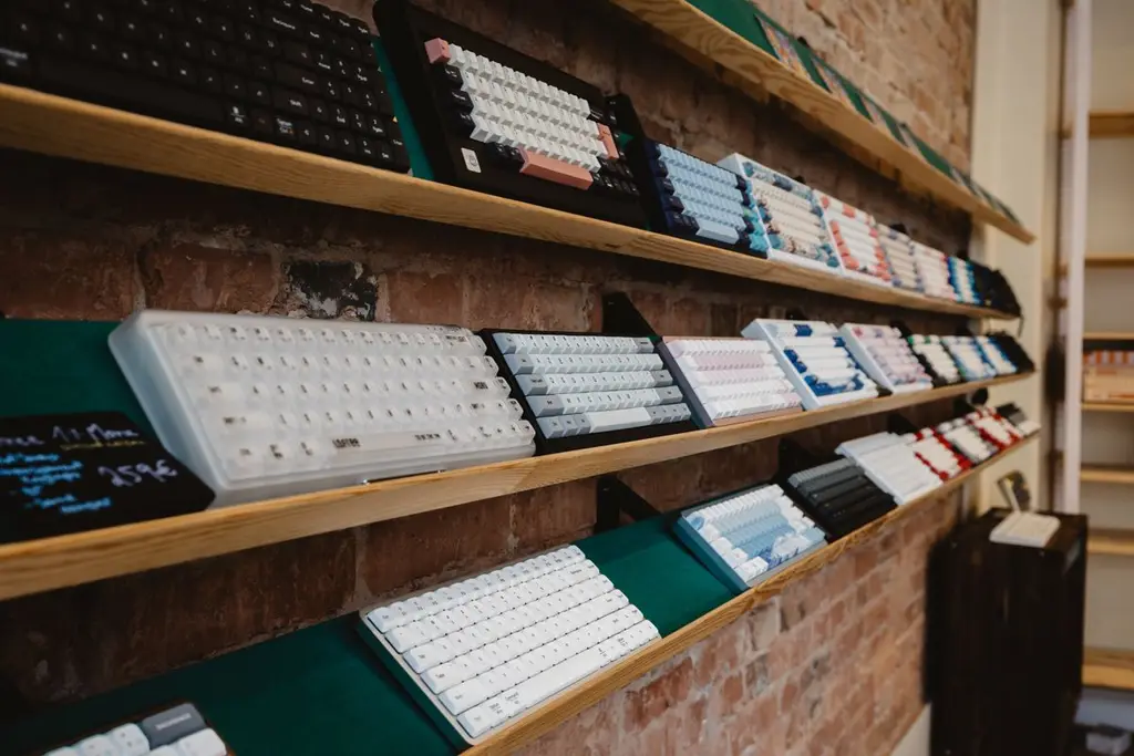 Rows of mechanical keyboards on a wooden shelf
