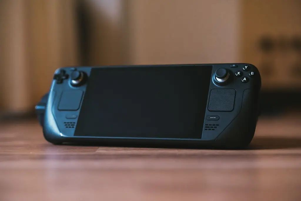 A handheld gaming PC resting on a wooden table