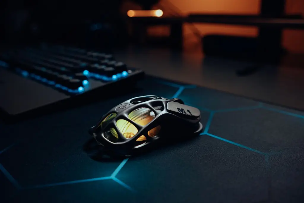 A glowing futuristic gaming mouse on an RGB-lit desk