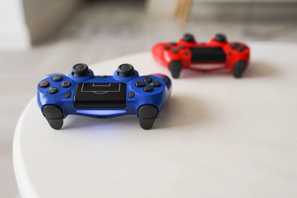Two PlayStation controllers on a white table